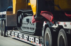 Long Haul Heavy Duty Construction Machinery Transportation on a Semi Truck Trailer. Excavator Delivery.